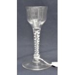 An 18th century wine glass, circa 1755, the plain ogee bowl supported on an opaque, four strand