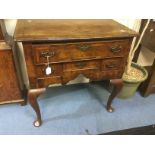 Early Georgian walnut lowboy on padded feet, three drawers, brass swing handles, mahogany legs