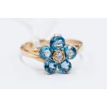 An aquamarine and diamond flower set cluster, comprising five round cut aquamarines, with a