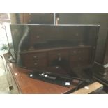 A flat screen TV Samsung with controllers