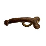 A complete cast copper-alloy phallic pendant or fascinus dating to the Roman period, c. AD 43-410.