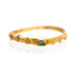 A gold and gem stirrup type ring dating to the Medieval period, c. 1200-1300. The ring demonstrates