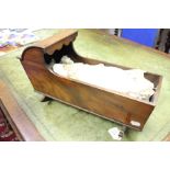 A late 19th Century mahogany rocking crib, 43 cms long approx along with doll