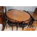 A 1960's teak round extending table with four matching chairs .