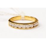 A diamond eternity ring, channel set with nine brilliant cut diamonds, in 18ct gold, total diamond