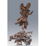 A large 19th Century Chinese root carving of a bearded deity, standing on one leg grinning,
