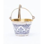 A boxed Russian silver tea strainer in the style of a decorated pail