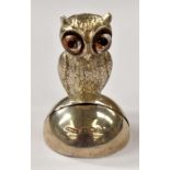 An Edwardian silver menu holder in the form of a standing owl, with inset glass eyes, sponsor's