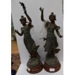 A pair of French spelter sculptures of ladies with floral bouquets, named Chrysanthemum and Anemone