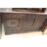 A late 17th Century planked coffer with three carved front panels and two drawers to base.