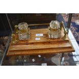 An early 20th Century light oak ink stand with pair of cut glass ink wells