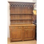 A  20th Century oak dresser and plate rack. The base having two drawers with brass handles and two