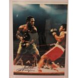 Boxing: A framed and glazed photograph bearing the full Joe Frazier autograph in black marker with