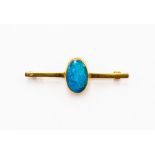 A black opal brooch, oval opal with blue and green play of colour, length approx14mm x 9mm, rub-over