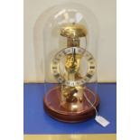 A 20th Century West German skeleton clock, circa 1970's with glass globe, teak plinth