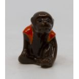 A porcelain model of a seated monkey wearing an orange cape, unmarked in the manner of Bernard