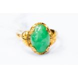 A jadeite oval set dress ring, claw set jadeite 11mm x 7mm, unmarked yellow metal testing as 18ct