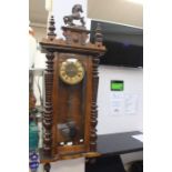A late 19th Century/early 20th Century walnut Vienna wall clock, prancing horse finial, key and