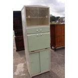 A 1950's green and cream kitchen cabinet with glazed upper sliding doors , small drawer, pull down