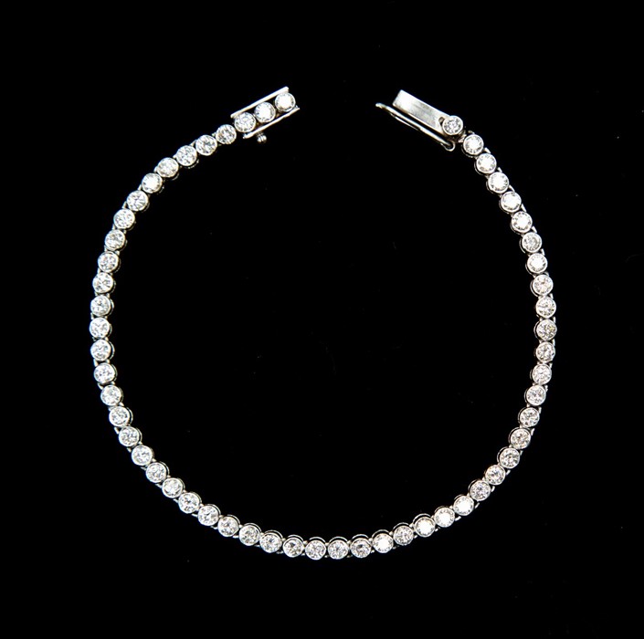 A diamond tennis bracelet, rub-over set with approx 7'', fifty six round brilliant cut diamonds,
