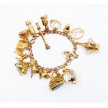 A 9ct gold charm bracelet with various 9ct gold and unmarked yellow metal antique seals, acorn,