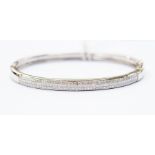 A diamond set 18ct white gold bangle, comprising three rows of princess cut diamonds set to the