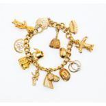 A 9ct gold charm bracelet with various charms, including a horse, scarecrow, ship, engagement ring