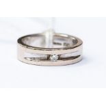 A diamond set 18ct white gold band, milled line to the centre set with brilliant cut diamond,