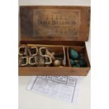 A boxed table billiards set, retailed by A.W. Gamage and Benetfink and Co, converts dining table