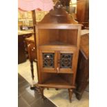 An oak corner stand with stained glass cupboard.