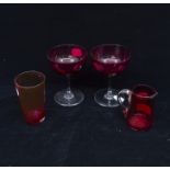 A cranberry glass cream jug and a pair of ruby glass champagne coups, plus a small tumbler