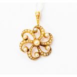 A Edwardian 15ct gold and seed pearl pendant brooch, open scroll design set with graduated seed