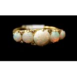 An opal five stone ring, comprising five graduated round cabachon opals, diamond accents set in