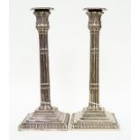 A pair of silver plated column candlesticks