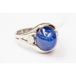 A sapphire and diamond ring, the central cabachon sapphire weighing approx 12 carats, diameter