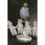 Four Continental child ceramic dolls, in rabbit outfits with moving arms, ceramic baby in crib and a