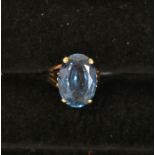 A blue topaz dress ring, the oval claw set stone approx 17mm x 12mm, set to spilt shoulder  9ct gold
