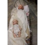 Early 20th Century metal dolls bed with canopy and two baby dolls, one is French