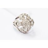 A diamond set cluster ring, openwork boule head setting, scroll and foliate decoration set with gain