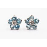 A pair of aquamarine and diamond flower cluster earrings, set with round stones and a diamond set