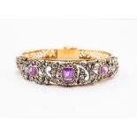 A Victorian style bangle comprising three emerald  cut amethysts set within open scroll work details