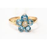 An aquamarine and diamond flower set cluster, comprising five round cut aquamarines, with a
