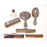 A group of silver dressing table items including three combs, mirror, perfume bottle with silver