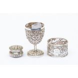 A collection of white metal items to include an Indian silver egg cup, a continental silver pill box