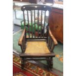 A 19th Century oak cane seat rocking chair, heavily turned