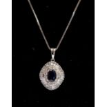 A sapphire and diamond set pendant, oval in form, claw  set to the centre with an oval blue