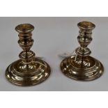 A pair of Elizabeth II sterling silver loaded dwarf candlesticks in the George II style, of turned