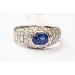 A sapphire and diamond dress ring, set with an oval sapphire, (possibly Ceyon origin) rubover set,