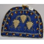 A silk tea cosy with pearl and bead grapevine detail, dark blue silk material