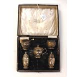 A George V sterling silver boxed condiment set comprising peppers, salts and mustard pot and spoon,